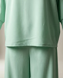 Compleu damă din două piese verde mentă, bluză cu decupaje și fundițe pe mâneci și pantaloni largi, stil casual-elegant