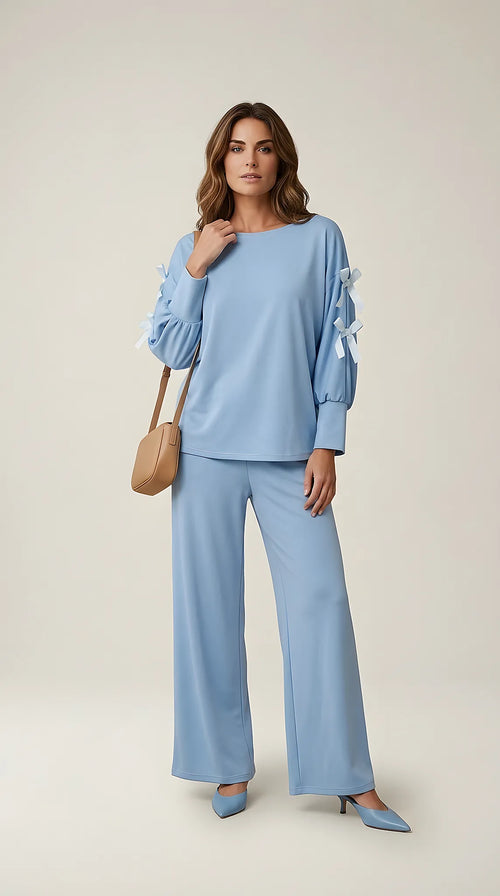 Compleu de damă albastru ciel din două piese, cu pantaloni largi și bluză cu mâneci lungi și fundițe decorative pe umeri, stil casual-elegant