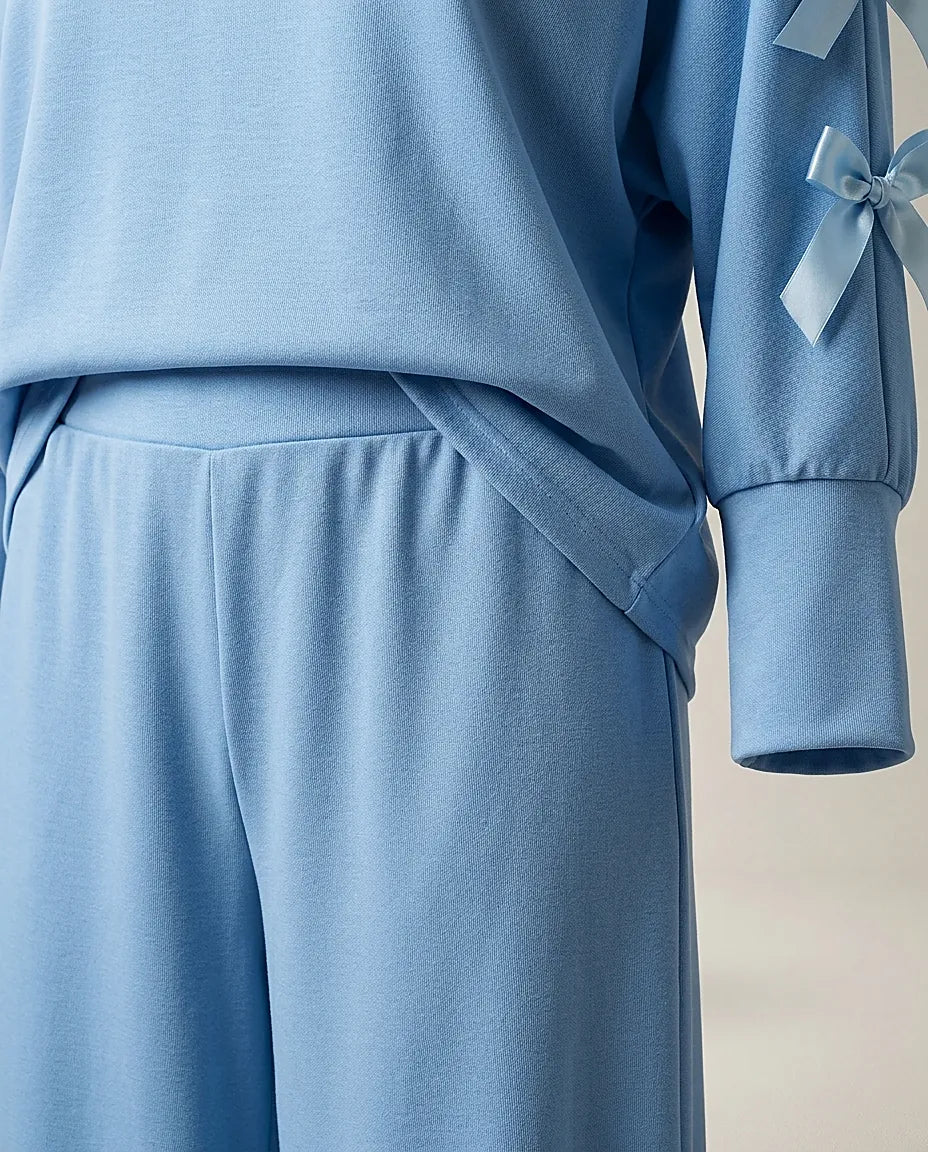 Compleu de damă albastru ciel din două piese, cu pantaloni largi și bluză cu mâneci lungi și fundițe decorative pe umeri, stil casual-elegant