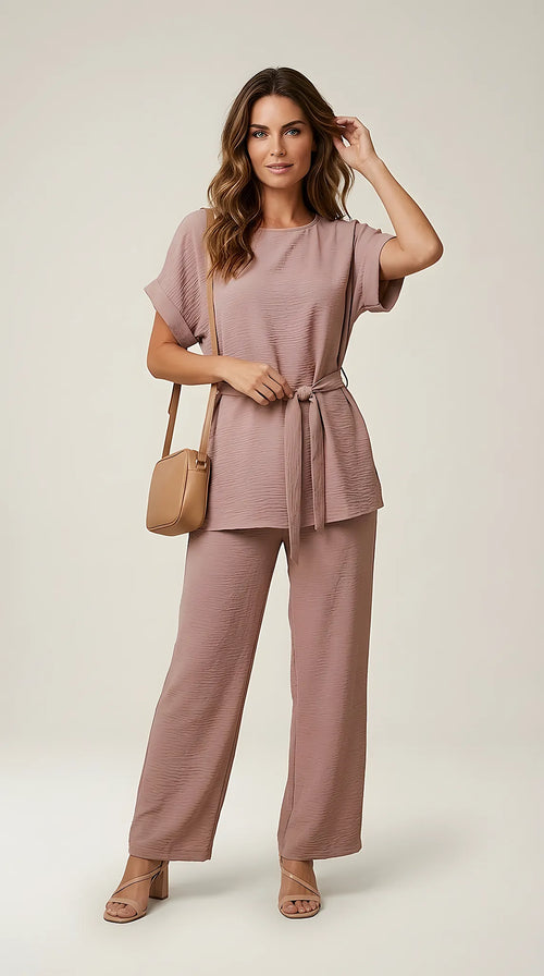 Compleu de damă elegant-casual din două piese, culoare bej-maroniu, cu bluză lejeră, mâneci scurte și pantaloni largi, cordon în talie și textură creponată