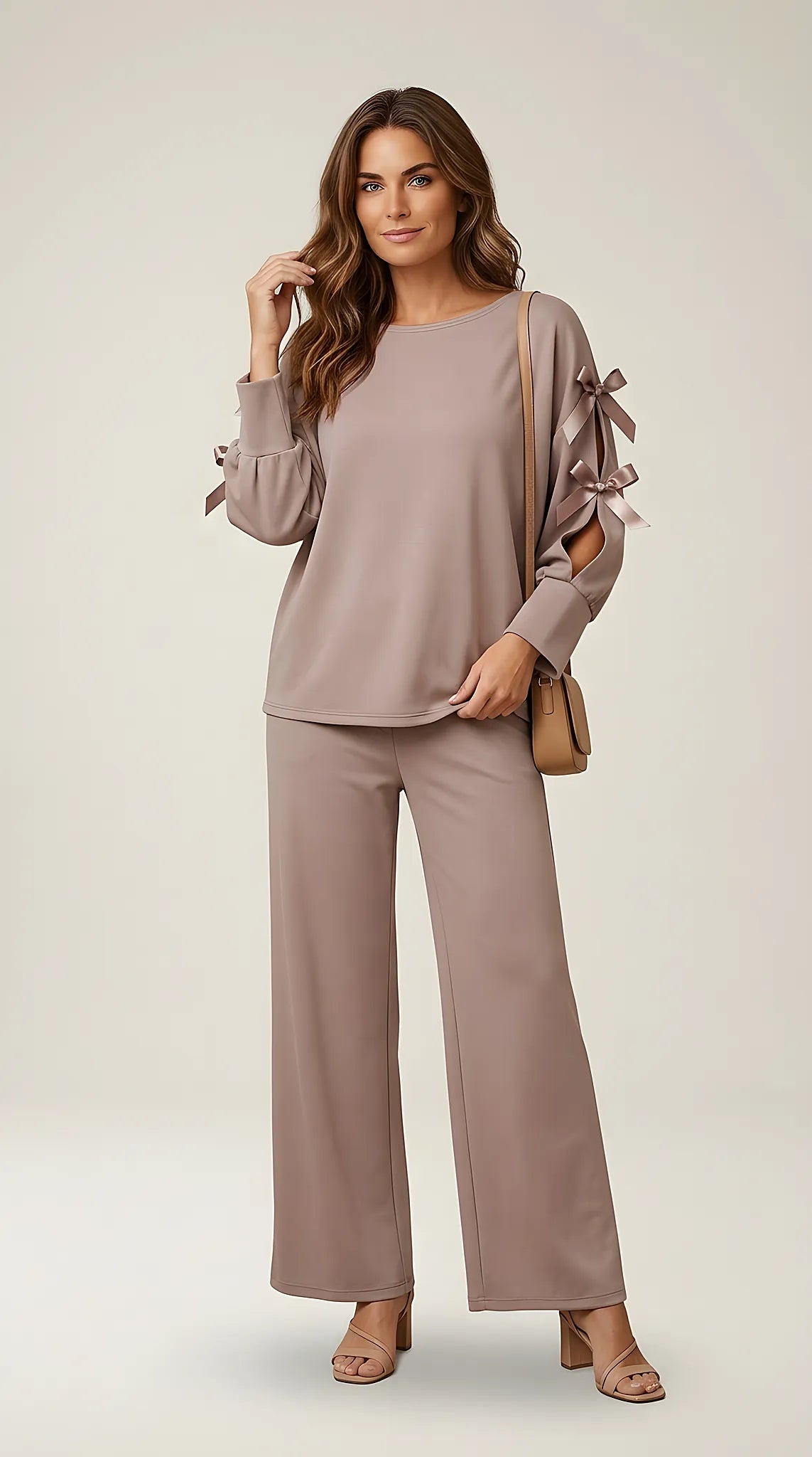 Compleu de damă elegant-casual din două piese, culoare taupe rozaliu, cu bluză cu mâneci decupate și fundițe satinate și pantaloni palazzo