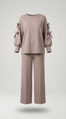 Compleu de damă elegant-casual din două piese, culoare taupe rozaliu, cu bluză cu mâneci decupate și fundițe satinate și pantaloni palazzo