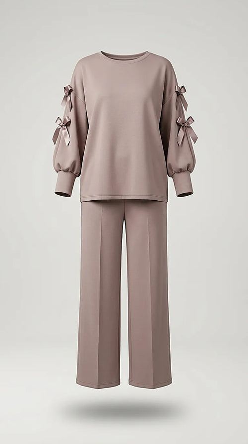 Compleu de damă elegant-casual din două piese, culoare taupe rozaliu, cu bluză cu mâneci decupate și fundițe satinate și pantaloni palazzo