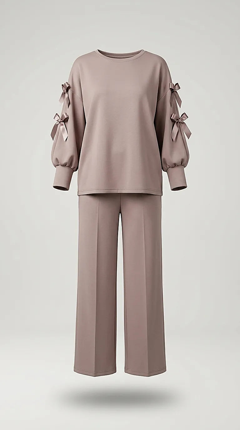 Compleu de damă elegant-casual din două piese, culoare taupe rozaliu, cu bluză cu mâneci decupate și fundițe satinate și pantaloni palazzo