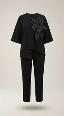 Compleu elegant de damă negru din două piese, cu bluză asimetrică cu floare 3d decorativă și pantaloni conici