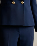 Costum elegant de damă bleumarin, două piese, cu sacou cambrat double-breasted și nasturi aurii, și pantaloni office