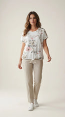 Tricou alb de damă cu imprimeu floral roz și mesaj inspirațional argintiu, mânecă scurtă și șnur reglabil în talie
