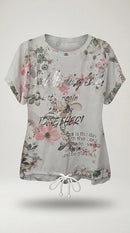 Tricou alb de damă cu imprimeu floral roz și mesaj inspirațional argintiu, mânecă scurtă și șnur reglabil în talie