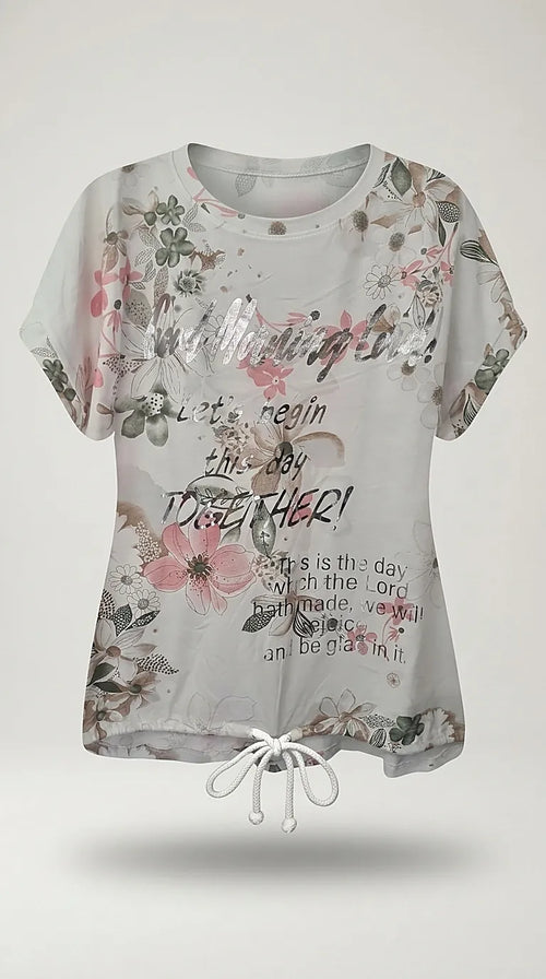 Tricou alb de damă cu imprimeu floral roz și mesaj inspirațional argintiu, mânecă scurtă și șnur reglabil în talie