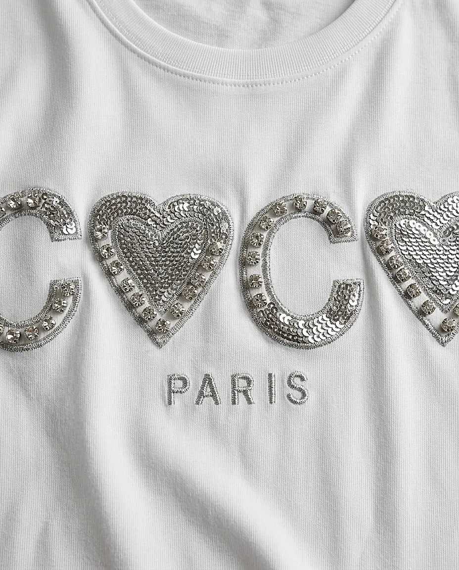 Tricou alb de damă din bumbac cu imprimeu 'coco paris' decorat cu paiete argintii și cristale