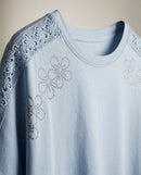 Tricou damă elegant albastru deschis cu aplicații florale din strasuri și inserții de dantelă la umeri, mânecă scurtă din bumbac