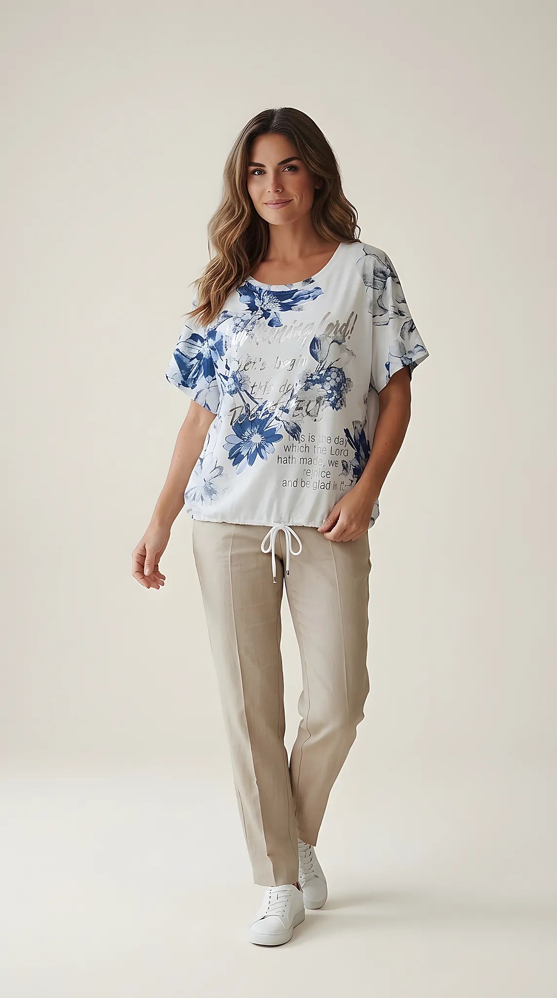 Tricou de damă alb cu imprimeu floral albastru și text argintiu metalizat, mânecă scurtă cu șnur în talie, stil casual
